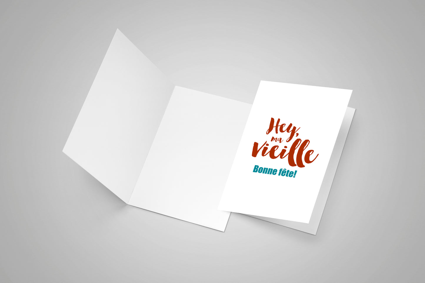 Blank open greeting card and a second closed greeting card with an Acadian birthday saying on the front.