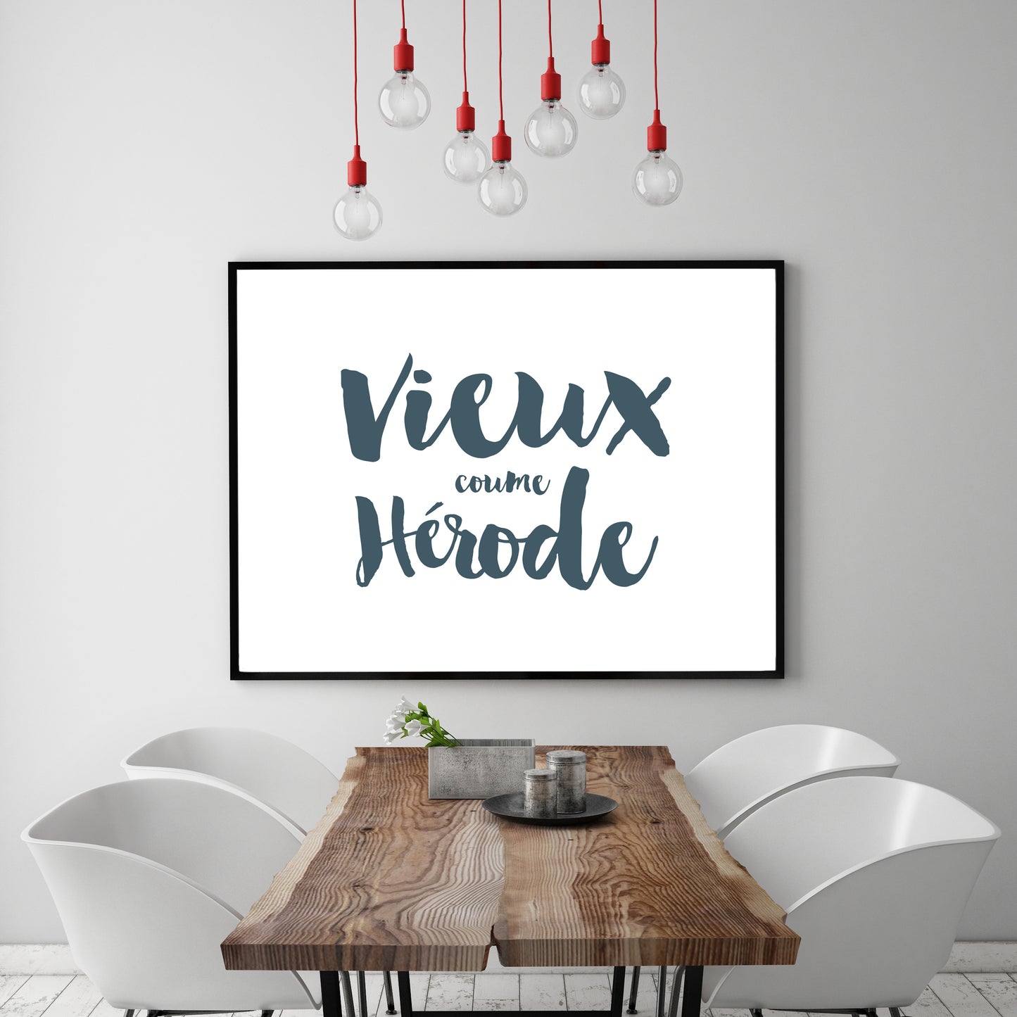 An Acadien / Acadian word print framed on a wall above a table.