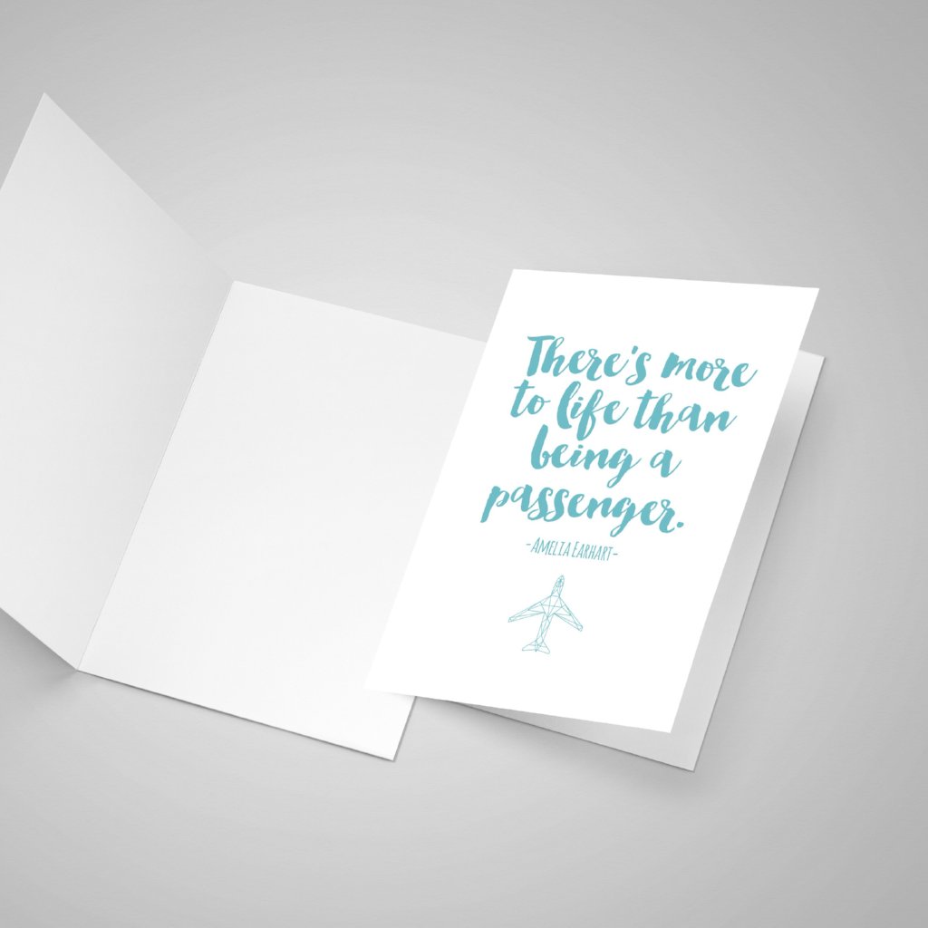 Open blank card and one closed greeting card of an Amelia Earhart quote. The text is in teal and her quote saying "There is more to life than being a passenger."
